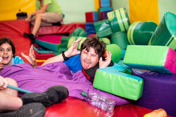 Young boy in soft play area, he is sticking in tounge out and looks happy