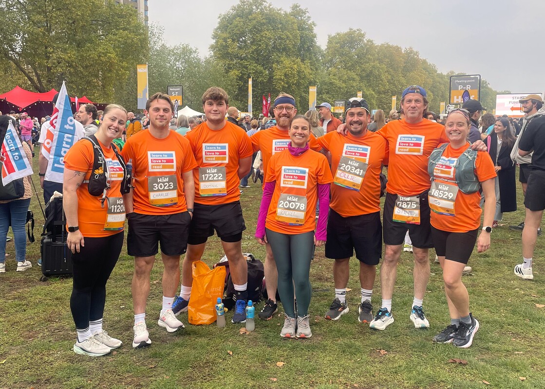 Royal Parks Half Marathon group of runners holding Learn to Love to Read signs