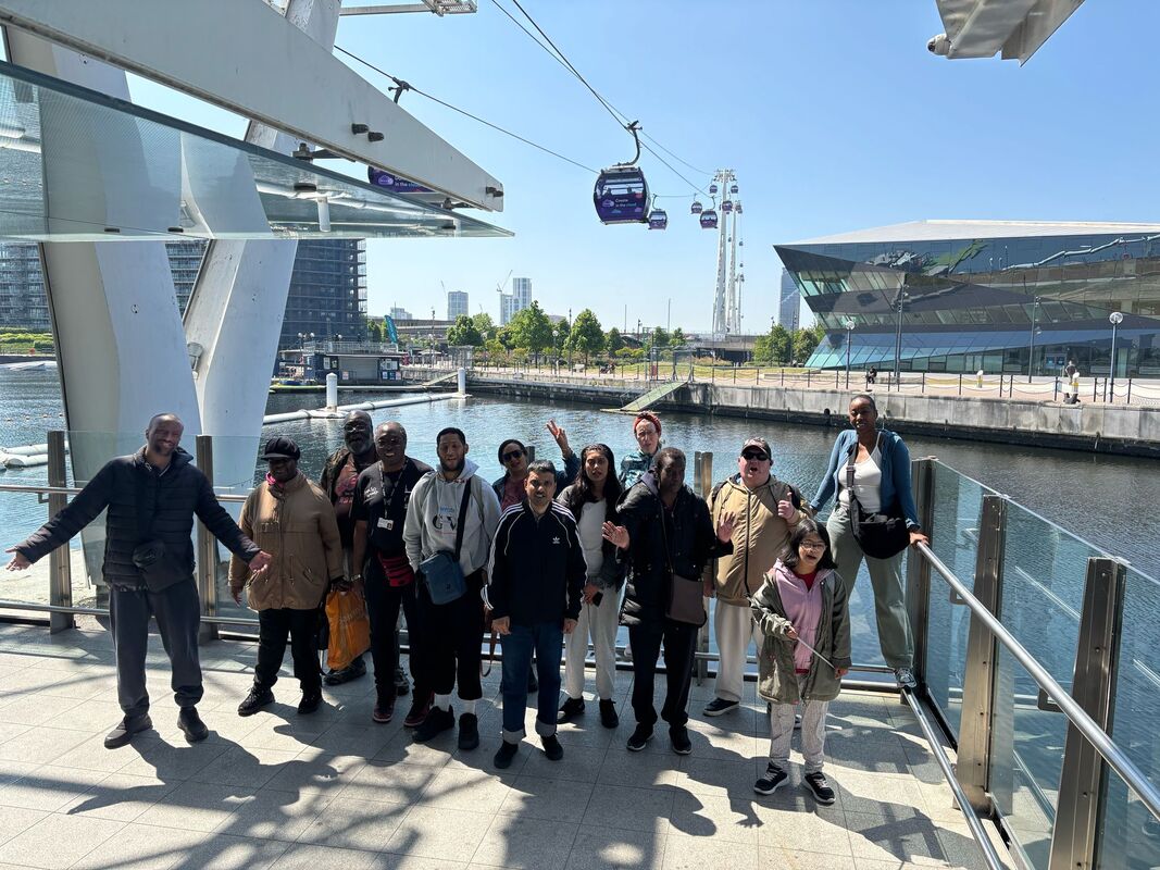 TfL Cable Car Focus Group members standing in front of the Cable Car overlooking the River Thames.