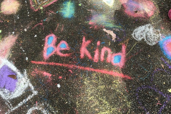 Words Be Kind chalked on the road
