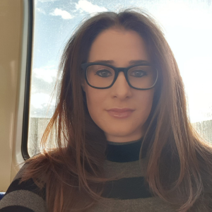 An image of Katy Mutemi. She has dark, straight hair and is wearing black glasses.