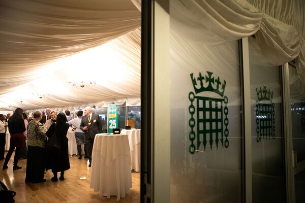 A photo from outside Respect's 25th anniversary event, looking through a door with the parliamentary logo visible on it.