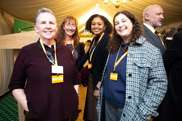 A photo of four women smiling at Respect's 25th anniversary event.