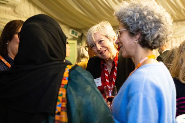 A photo of Baroness Theresa May talking to a group of women at Respect's 25th anniversary event.