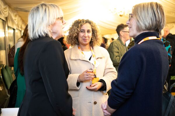 A photo of a group of women talking at Respect's 25th anniversary event.