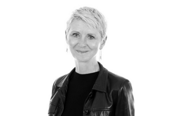 A black and white photo of Mary D'Arcy. She has short blonde hair and is smiling at the camera.