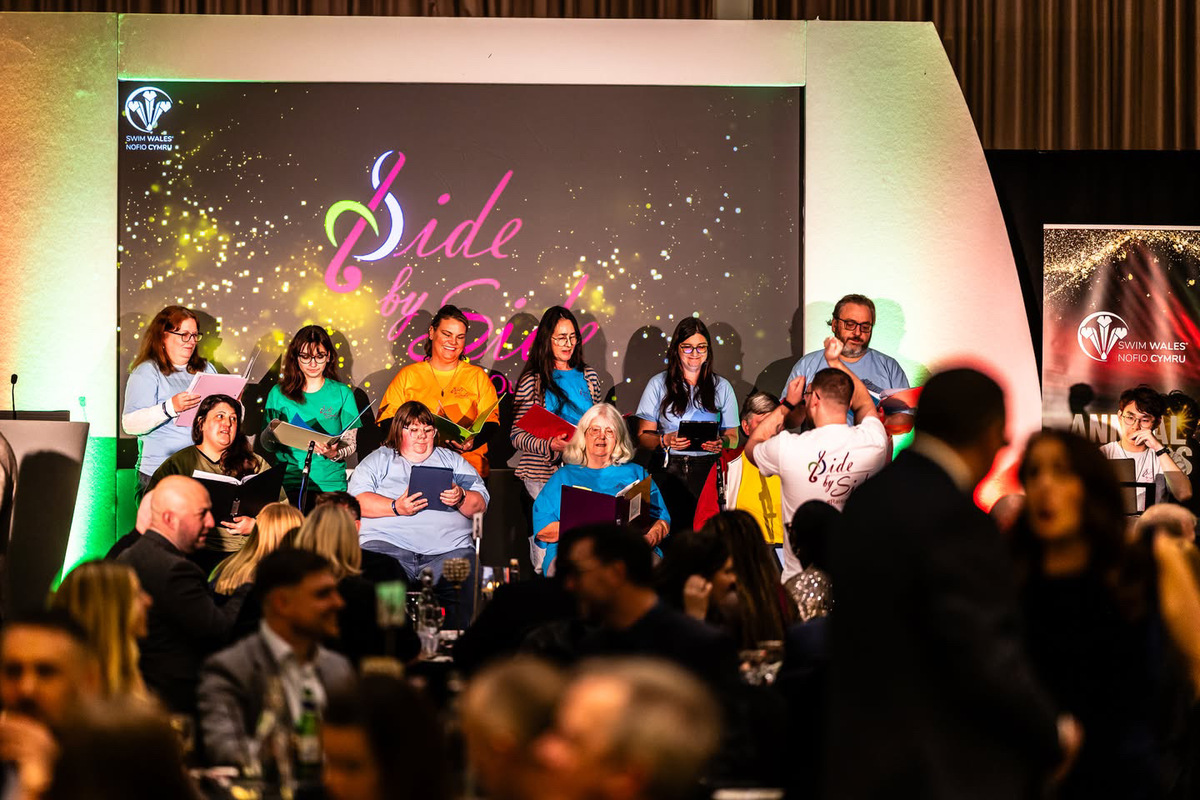 Members of Side by Side choir performing on stage at the Swim Wales Awards ceremony in January 2026.