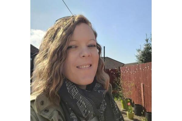 Photo of Kat Gower, Chairperson of Side by Side, smiling outdoors.