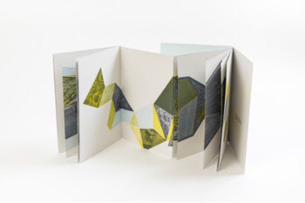 Photo of an artist book with a fold-out accordion with an abstract geometric pattern in green