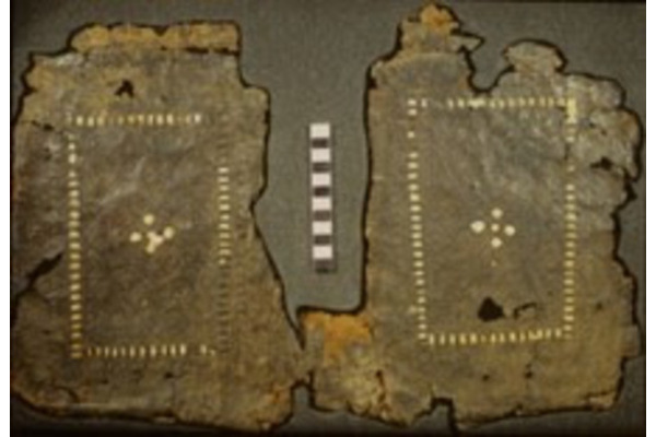 A photo of a fragmentary archaeological leather binding showing woven parchment decoration