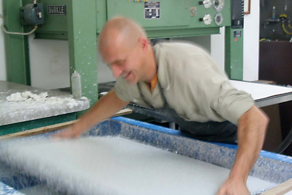 Gangolf pulling a sheet of paper from the vat