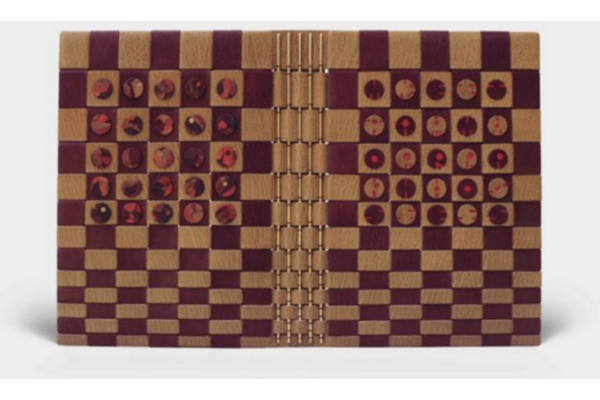 A fine binding of Metamorphoses bound by Mel Jefferson in chequered tan and burgundy goatskin with small round inlays in marbled red and tan. The book is sewn over exposed brass rods woven through tan strips of leather