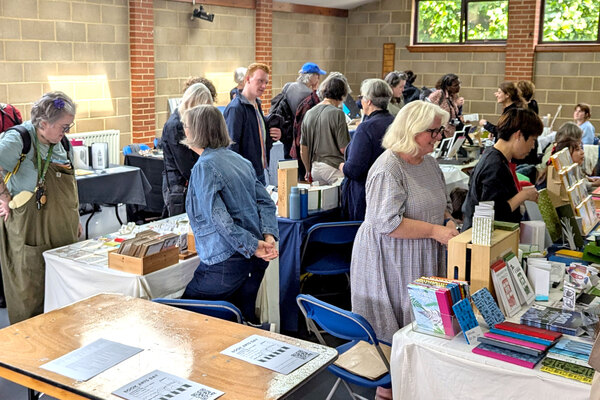 A crowd of people around tables at Book Arts Day