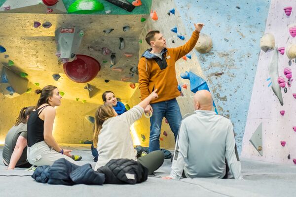 Students and advisor looking at a climbing wall