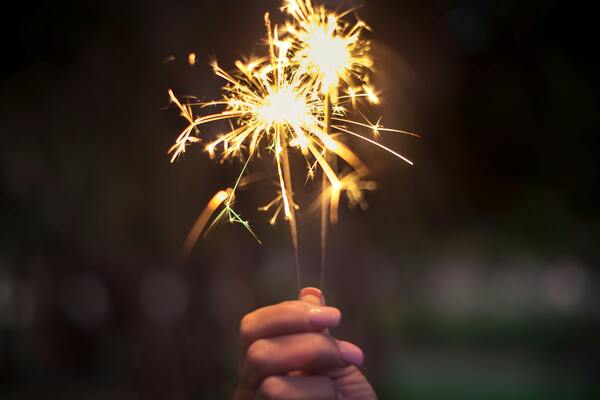 Person holding lighted sparkler