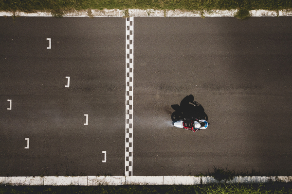 Overhead image of a motorcycle crossing a finish line